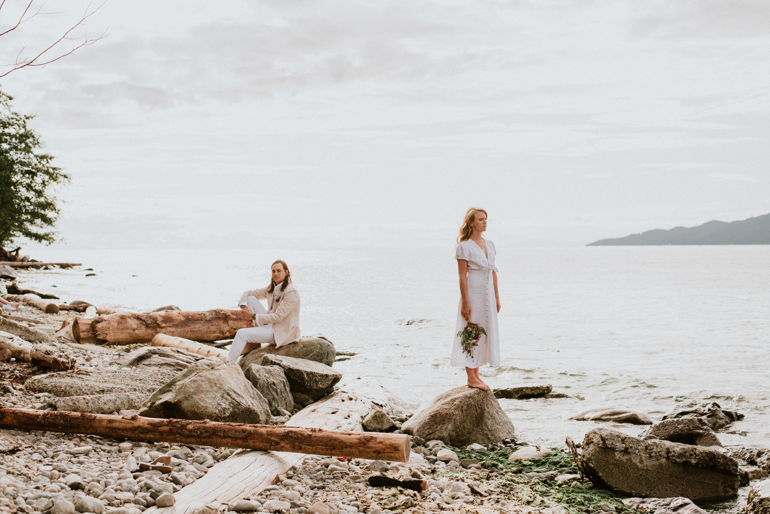 A bride and groom on a rocky beach at Spanish Banks in Vancouver BC